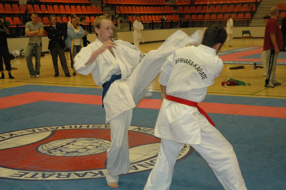 To voksne kæmpere i kontaktkarate; den ene sparker mod modstanderens hoved