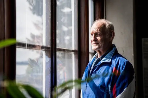 Jens Daugbjerg Bjerrekær i blå jakke ved et vindue i Viborg Hallen